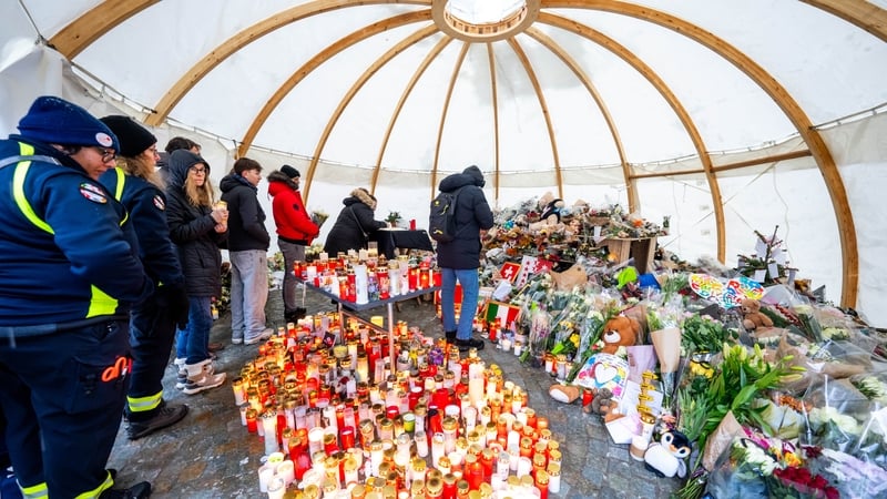 Attendees gather in mourning, placing messages, candles, and flowers at a memorial site in front of the bar “Le Constellation” during a national day of mourning in Crans-Montana, on January 9, 2026,