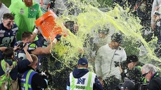 SANTA CLARA, CALIFORNIA - FEBRUARY 08: Head coach Mike MacDonald of the Seattle Seahawks is doused with Gatorade by Patrick O'Connell #52 of the Seattle Seahawks after beating New England Patriots to win Super Bowl LX at Levi's Stadium on February 08, 202