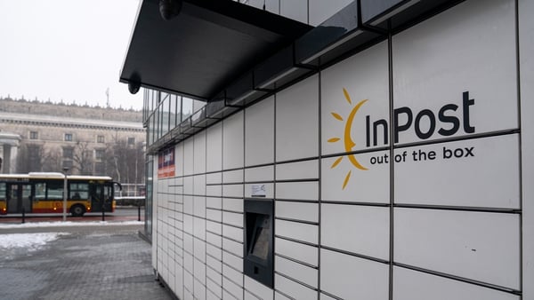 A bank of while parcel lockers with the InPost Logo on them on a wintry street