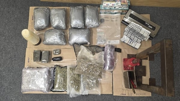 Bags of seized drugs and money placed on the ground
