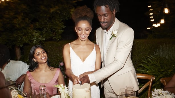 Happy married couple cutting wedding cake