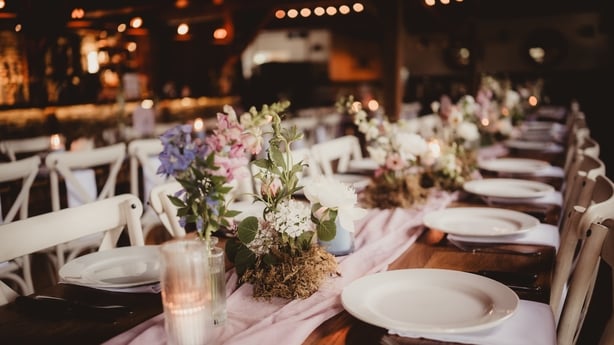 Centerpieces at a wedding with flowers, candles and ribbon