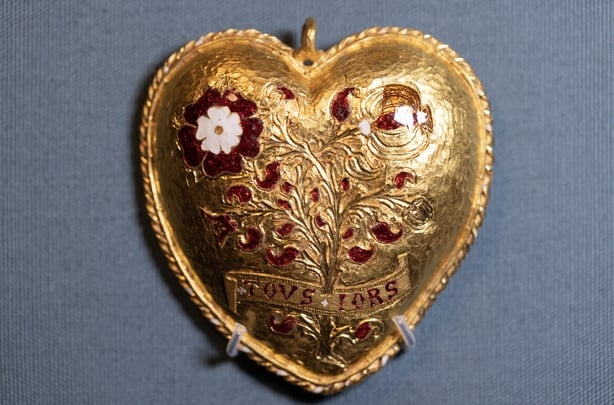 A gold pendant is displayed 