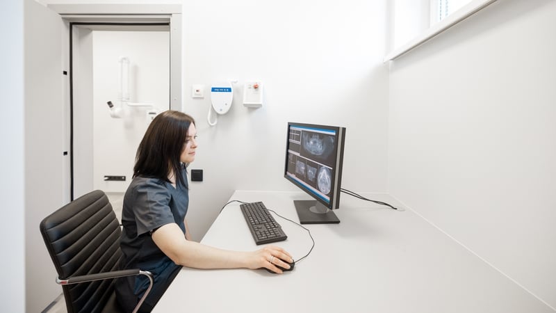Doctor looks at the 3d scan of the jaw on the computer in office near X-ray room