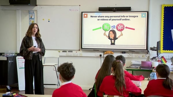 A woman gives a presentation on Internet safety in a classroom