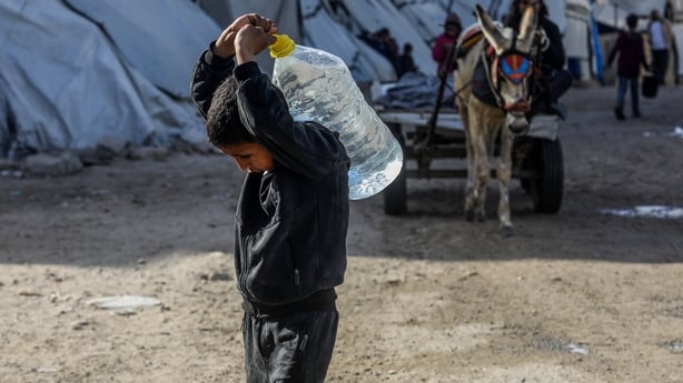 KHAN YUNIS, GAZA - FEBRUARY 10: Residents collect water in containers from tanker trucks and carry it back to their living areas due to a severe water crisis, following extensive damage to infrastructure caused by Israeli attacks, in Khan Yunis, Gaza, on February 10, 2026. (Photo by Abed Rahim Khati