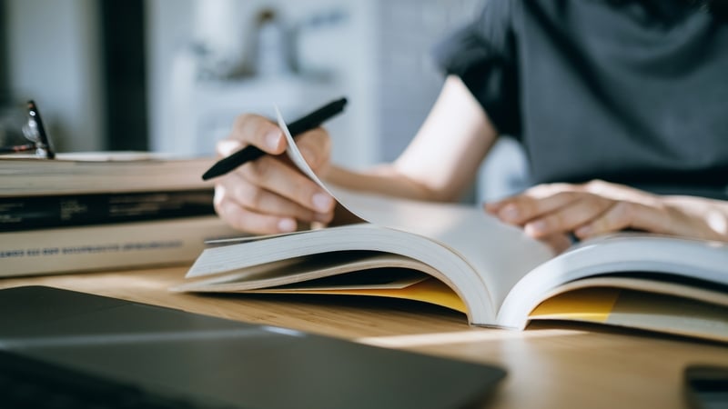generic image of woman studying with books on a table