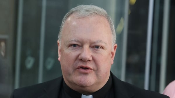 a photograph of Fr Paul Murphy speaking to reporters