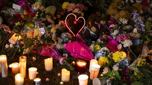 Flowers and candles form a memorial