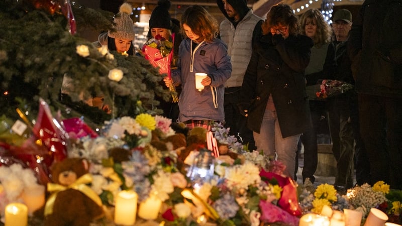 People hold candles at a vigil