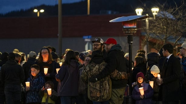 Community members mourn during a candlelight vigil 