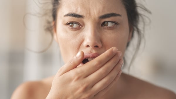 Woman is checking smell of breath