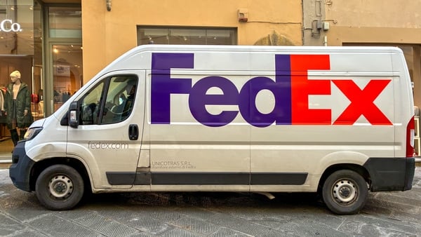 A van with FedEx signage is parked on a street