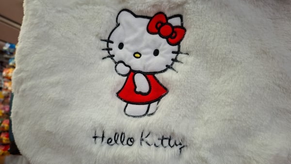 Embroidered Hello Kitty design on plush fabric, with red dress and matching bow