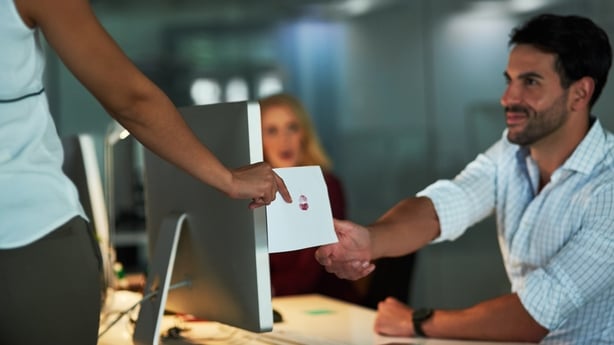 Shot of a love note being passed from a female colleague to a male colleague