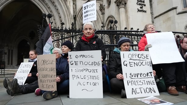 Protesters hold placards outside the High Court in central London