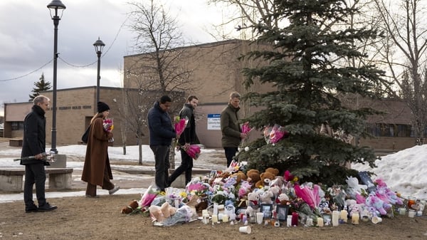 People bring flowers and pay their respects at a community vigil in Tumbler Ridge two days after the rural community experienced one of Canada’s deadliest shootings