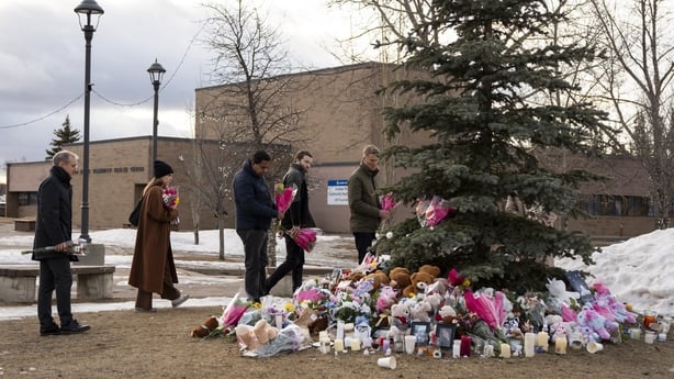People bring flowers and pay their respects at a community vigil in Tumbler Ridge two days after the rural community experienced one of Canada's deadliest shootings