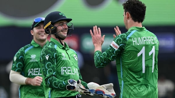 Ireland's Matthew Humphreys (R) celebrates with his captain Lorcan Tucker (C) after taking the wicket of Oman's Shakeel Ahmed during the 2026 ICC Men's T20 Cricket World Cup group stage match between Ireland and Oman at the Sinhalese Sports Club Ground in