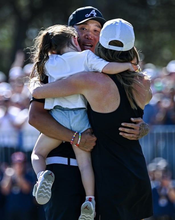 ADELAIDE, AUSTRALIA - FEBRUARY 15: Anthony Kim of the Aces hugs his daughter Bella and wife Emily after winning the tournament during day four of LIV Adelaide at The Grange Golf Club on February 15, 2026 in Adelaide, Australia. (Photo by Mark Brake/Getty Images)