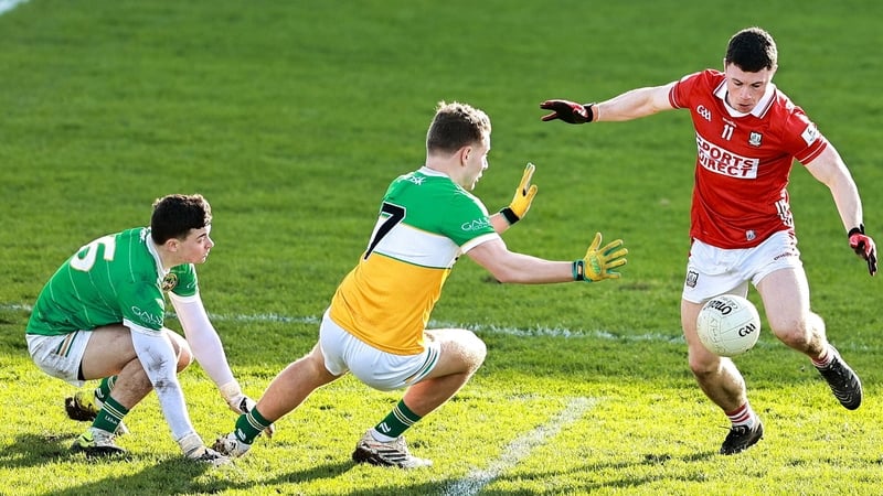 15 February 2026; Mark Cronin of Cork on his way to scoring his side's third goal despite the attention of Offaly goalkeeper Conor Melia and Rory Egan during the Allianz Football League Division 2 match between Offaly and Cork at Glenisk O'Connor Park in