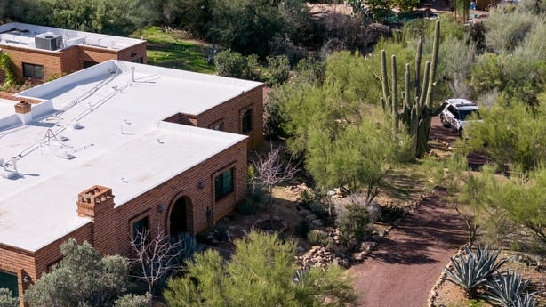 a Pima County Sheriff's deputy keeps guard outside of Nancy Guthrie's residence