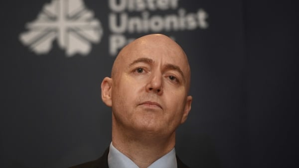 Ulster Unionist Party (UUP) leader Jon Burrows with a party sign behind him