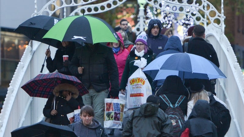 Crowd crossing the Ha'penny Bridge with umbrellas