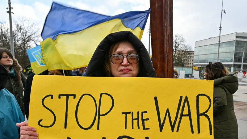 A protester holds a placard as a new round of talks between Russian, Ukrainian and US negotiators aimed at finding a solution to four years of fighting in Ukraine, takes place in Geneva