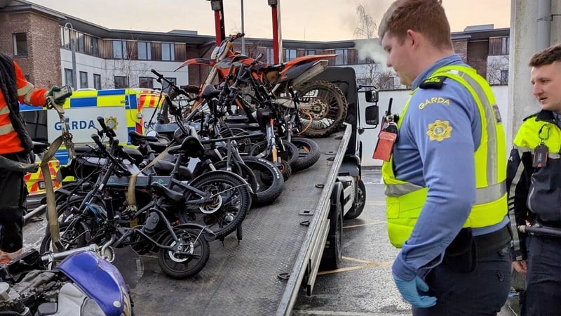 An Garda Siochana stand next to seized illegal bikes and scramblers