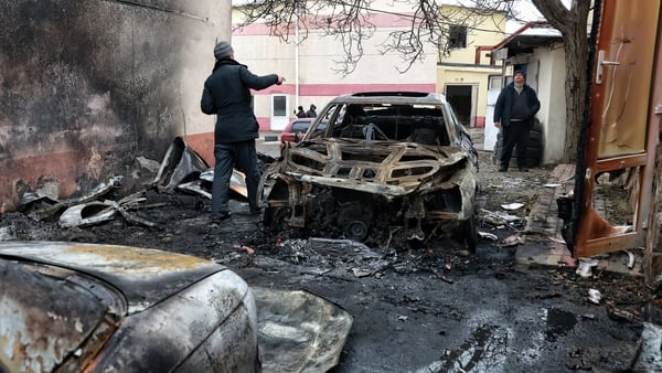 Men stand by a burnt-out car at an automobile repair shop damaged by an overnight Russian drone attack in Odesa, Ukraine, on February 17, 2026. Russian forces launch attack drones against the southern Ukrainian city of Odesa and the surrounding area, inju