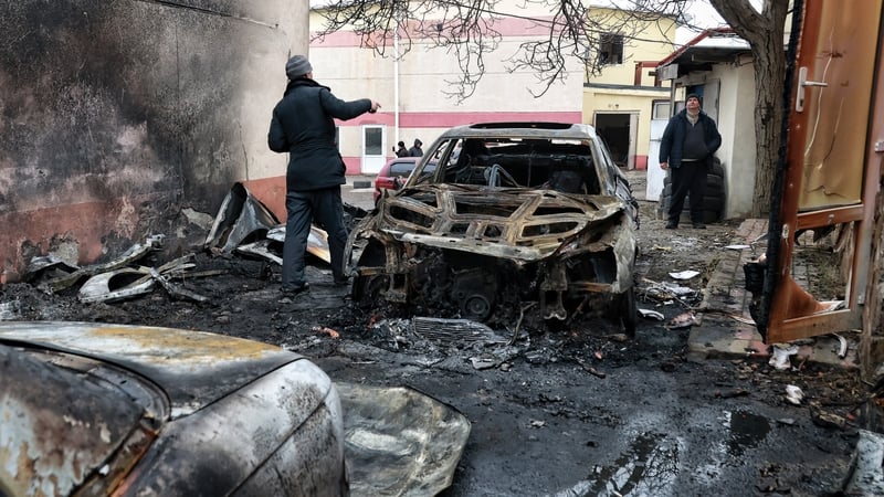 Men stand by a burnt-out car at an automobile repair shop damaged by an overnight Russian drone attack in Odesa, Ukraine, on February 17, 2026. Russian forces launch attack drones against the southern Ukrainian city of Odesa and the surrounding area, inju