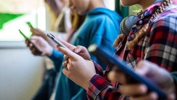 teenagers use phones in the school hallway