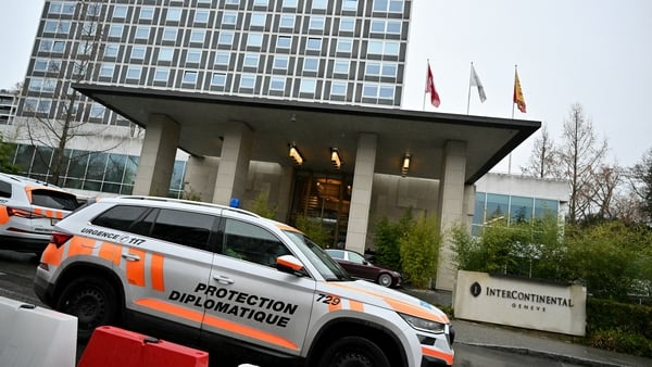 A Swiss diplomatic protection vehicle drives past a hotel