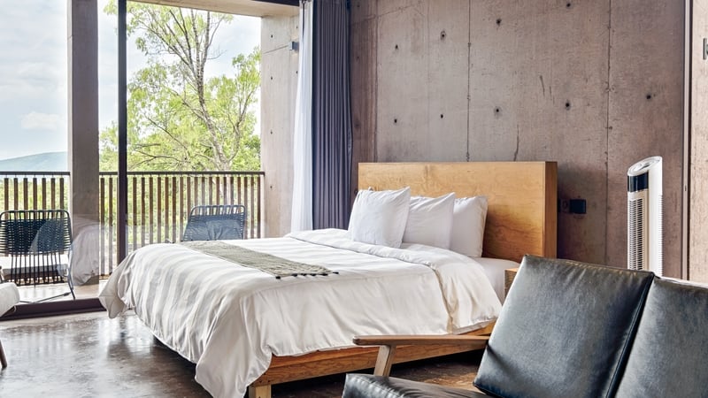 a stock photograph of a luxury hotel room with a king size bed and balcony