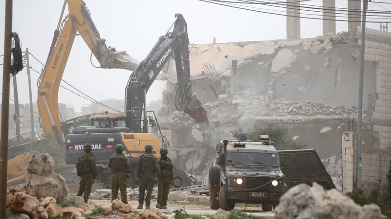 NABLUS, WEST BANK, PALESTINE - 2026/02/17: Israeli soldiers guard Israeli army bulldozers as they demolish a house in the al-Ta'awun neighborhood of Nablus in the West Bank. The Israeli army demolished five Palestinian homes in areas under the control of