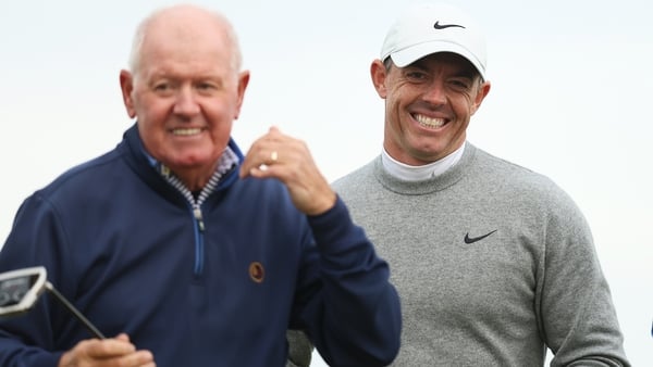 Rory McIlroy of Northern Ireland smiles alongside his father, Gerry, on the 18th green during day two of the Alfred Dunhill Links Championship 2024 at Kingsbarns Golf Links on October 04, 2024 in St Andrews,