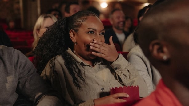 woman at the cinema, laughing at a movie