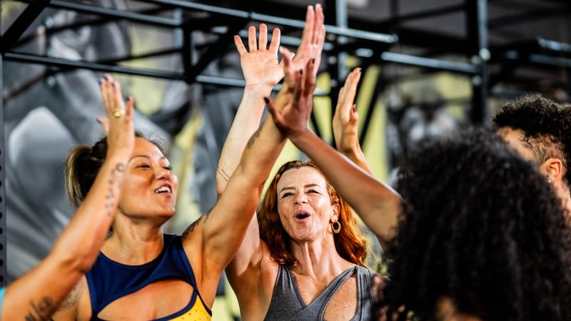 Friends celebrating holding hands at the gym