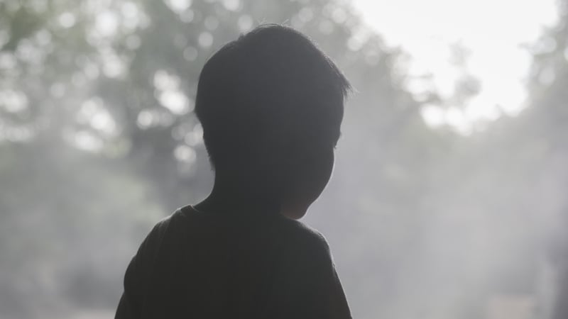 Asian boy walking through fog.