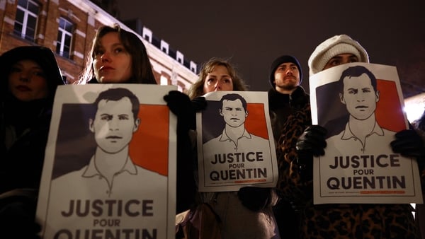 Demonstrators hold portraits during a rally in tribute of Quentin Deranque