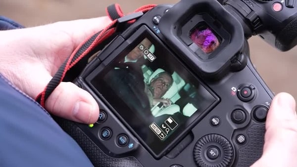 Photographer holding camera showing image of former Prince Andrew