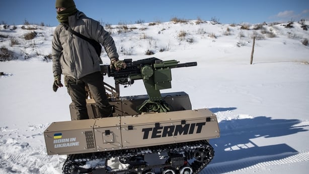 A soldier reloads a weapon mounted to a Tencore Unmanned Ground Vehicle 