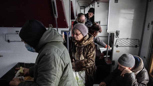 People receive hot meals in a train carriage that has been converted into a relief centre