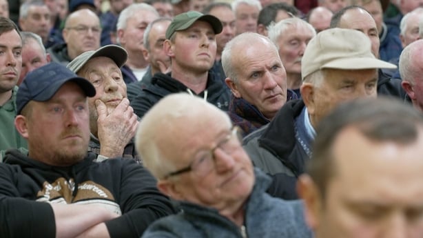 a close up photograph of a group of men gathered at a meeting 