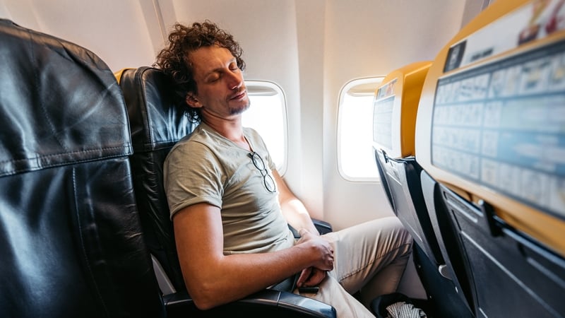 young man sleeping in an Airplane.