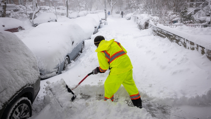 People shovel snow in the streets of Brooklyn as blizzard conditions continue on February 23, 2026 in New York City
