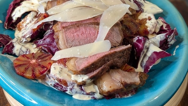 A plate of steak with cheese and blood orange