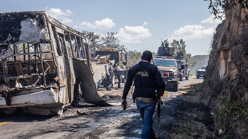 A convoy of the Mexican Army passes by vehicles set on fire in Morelia