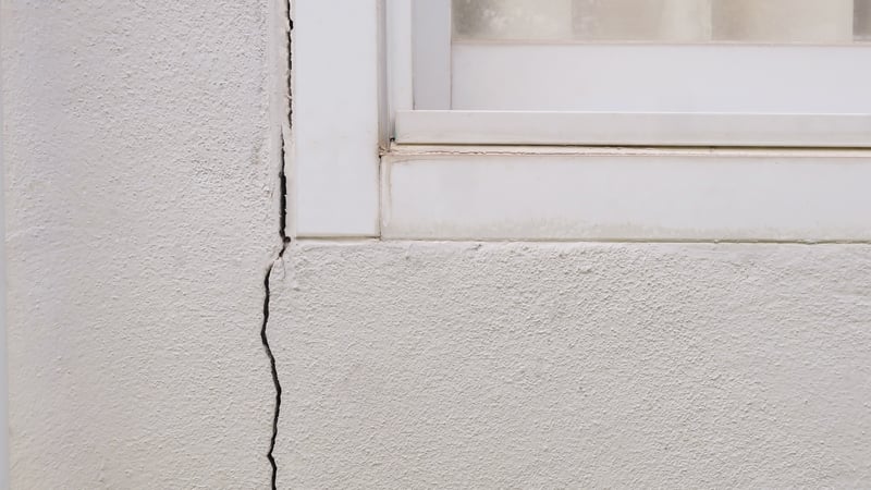 Cracked concrete wall at the adge of building window